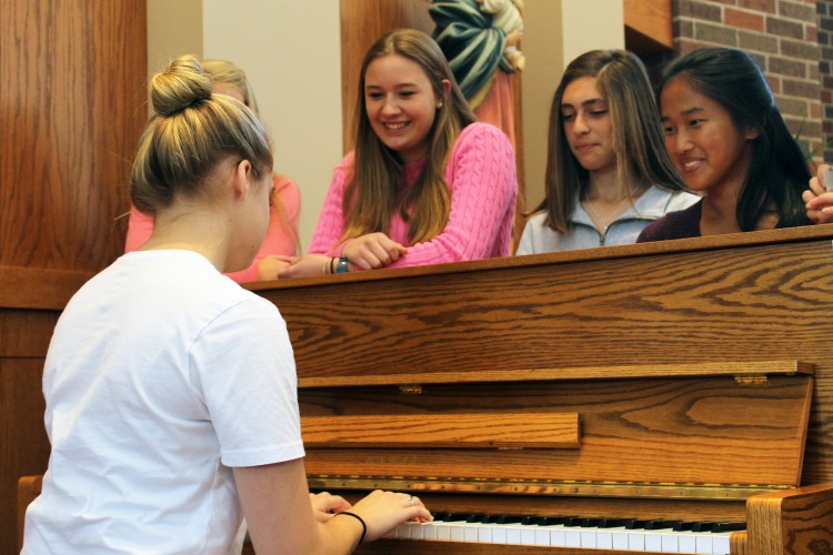 Senior Hannah Haughey entertains friends with the piano during lunch.