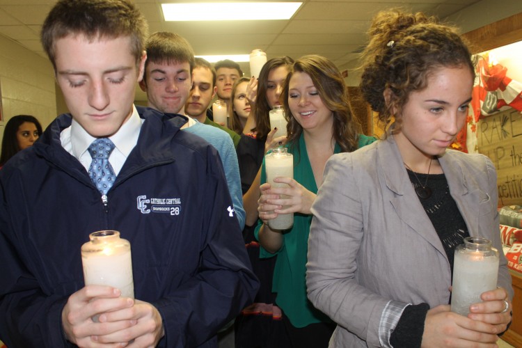 Students carry in candles in preparation for the Thanksgiving prayer service.