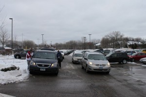 Snow piles in the parking lot are plowed to make way for parents and students who trek to school despite the weather. 