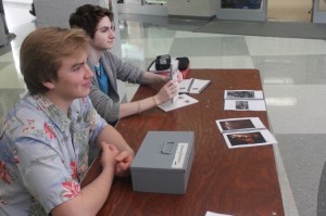 Seniors Archie Boyle and Ben Clark sell Apotheosis magazines in the main lobby before school.