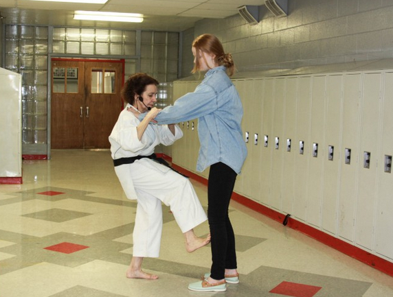 Freshman Claire Alme is instructed on how to properly defend herself by presenter Mary Brandl. The Black Belt instructor taught willing students how to spring into action while in dangerous situations.