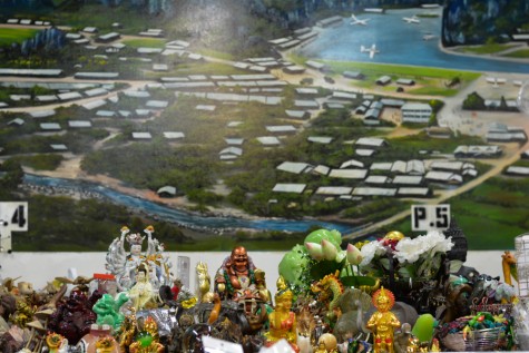 A Mural of a refugee camp is painted behind figurines for purchase at the Hmong Cultural Center.