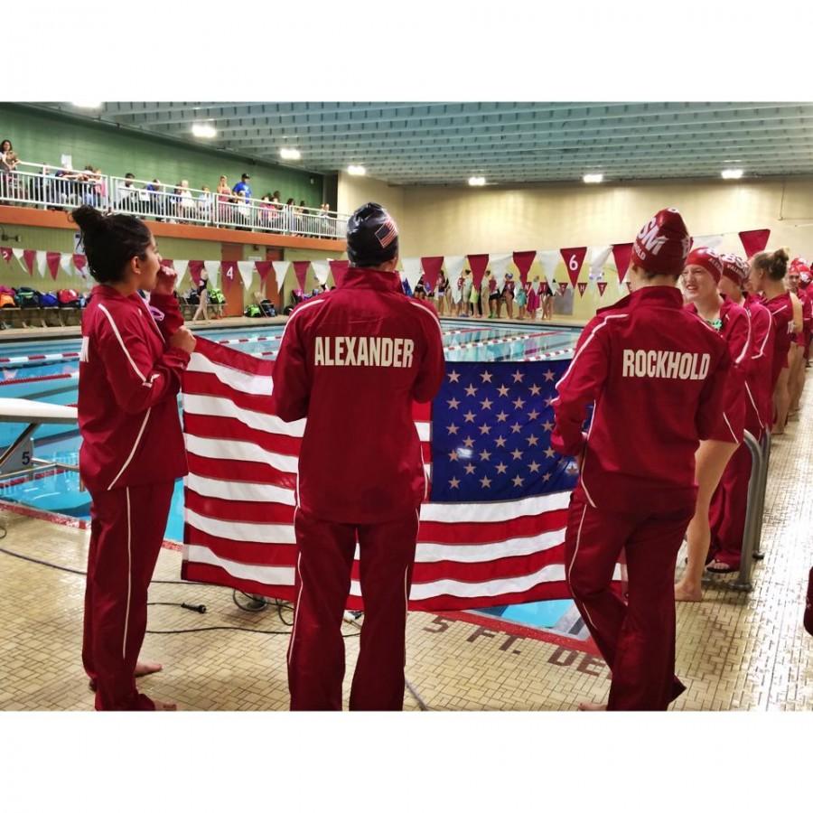 The former captains of the team hold the flag before a home meet last season.