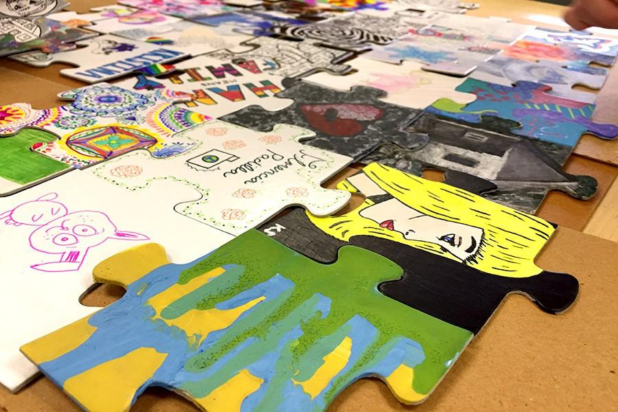 Puzzle pieces’ mediums varied from acrylic paint to markers, photos, fabric, or a combination of materials.