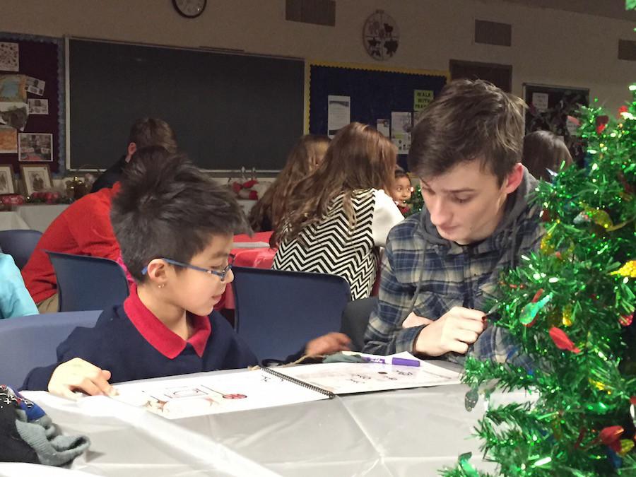 Junior Chase Mouser reads his original story with a student at Risen Christ. 