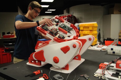 Engineering III student, Bryan Johnson, works on the robot the team will take to Germany.