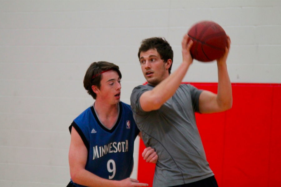 Junior Colin Segner shoves PE teacher Mr. Logan Radle during a game of intramural basketball. Radle also plays for the Minnesota Sting, a semi-pro football team that practices in Woodbury. 