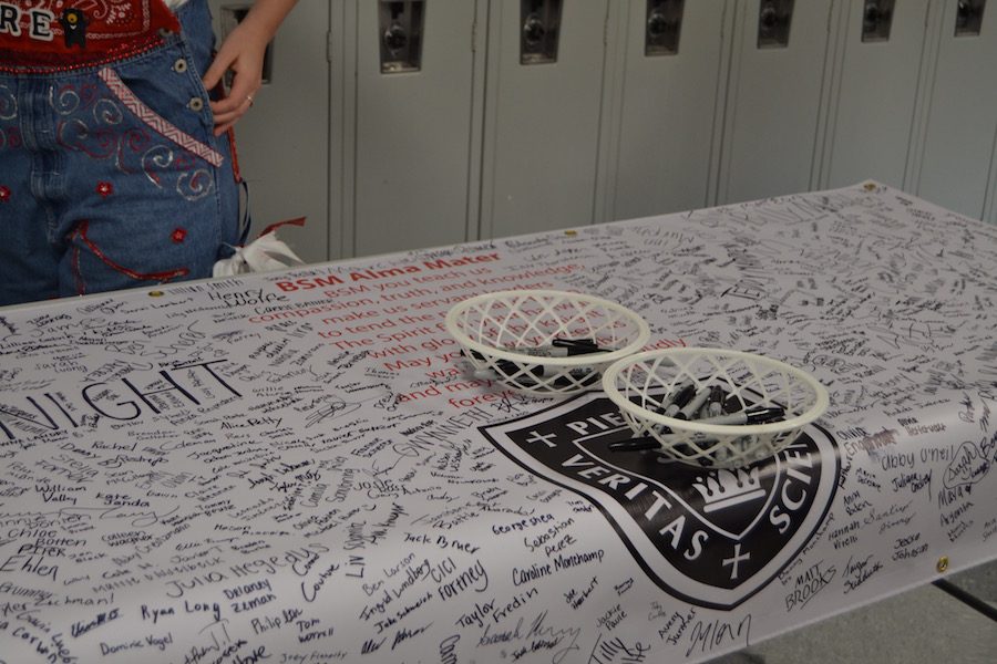 Students signed the new BSM banner before school with the Alma Mater written in the center.