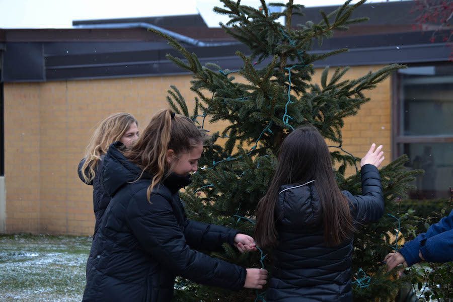 Knight Errant Designers and Editors decorate a tree to prepare for the Christmas Season.