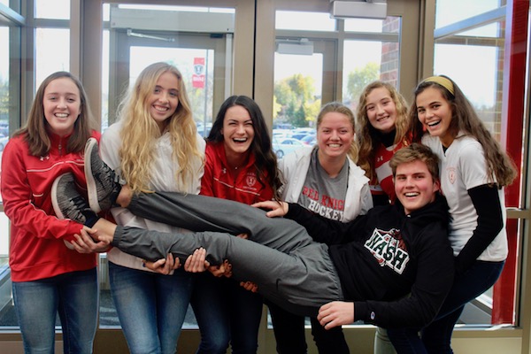 The girls soccer team carries Larson after his unwavering support outshines all of the other fans. 