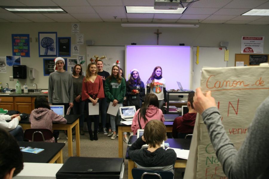 French students sang Christmas carols for a science class while their teacher held up posters to keep them from forgetting the words.
