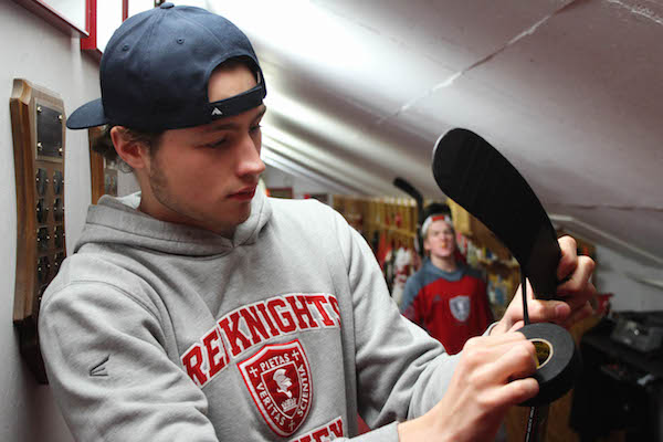 Senior boys hockey captain Joe Collins tapes his stick before playing.