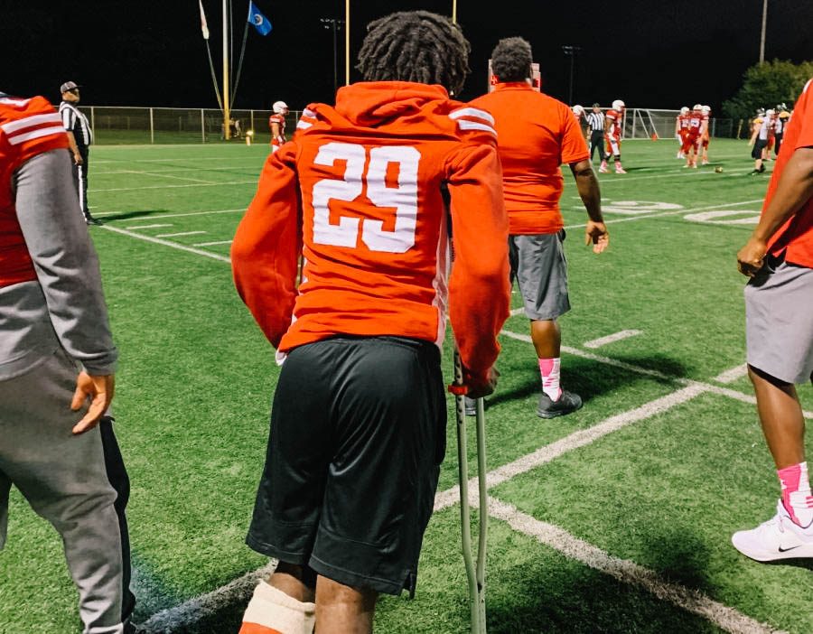 Isaiah Smith stands on the sideline of a football game