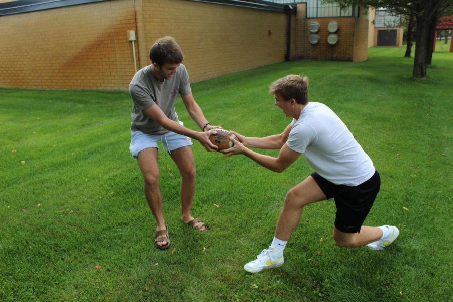 Seniors Matthew Nachbor and Zach Carden, who have differing opinions on the value of fantasy sports,  battle over a football. 