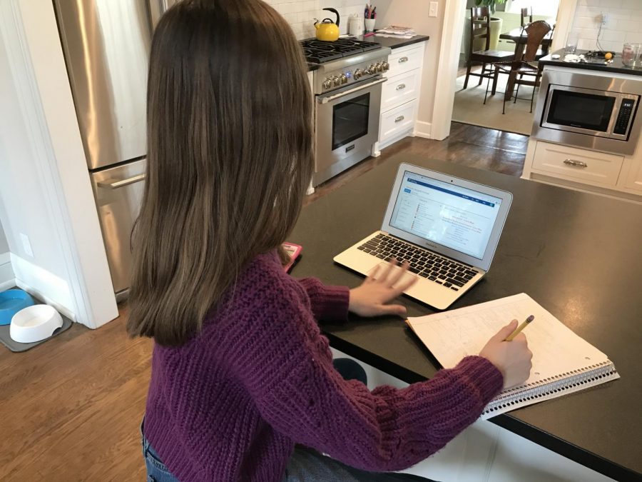8th grader Margaret Frohman completes her online assignments from her kitchen counter.
