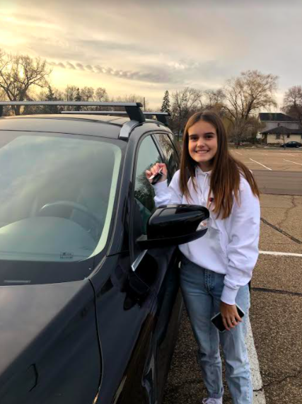 Sophomore Ella Kocourek poses with her car after driving to school. 