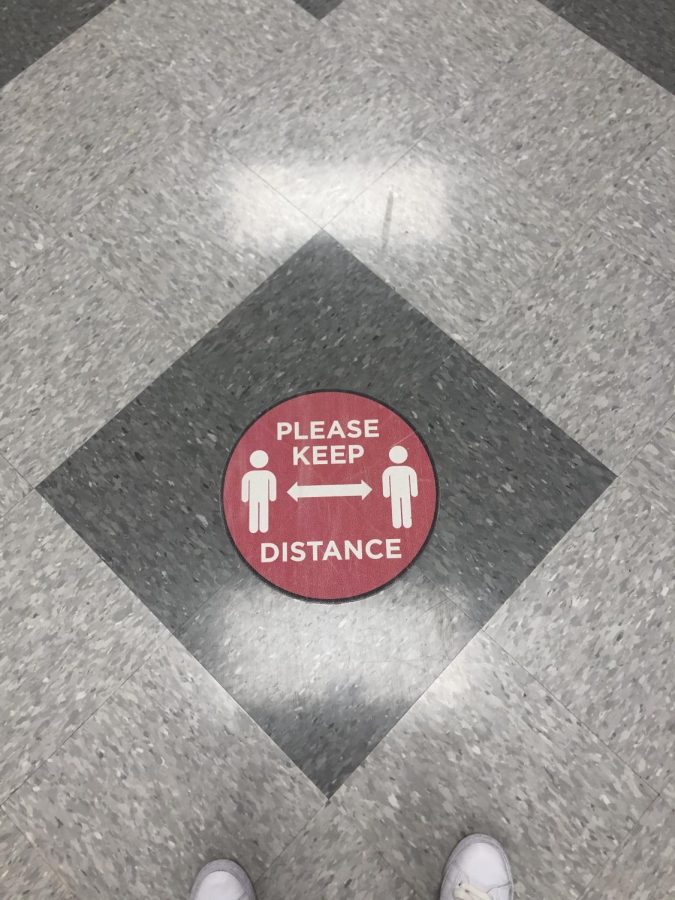 Signs remind students to keep their distance.