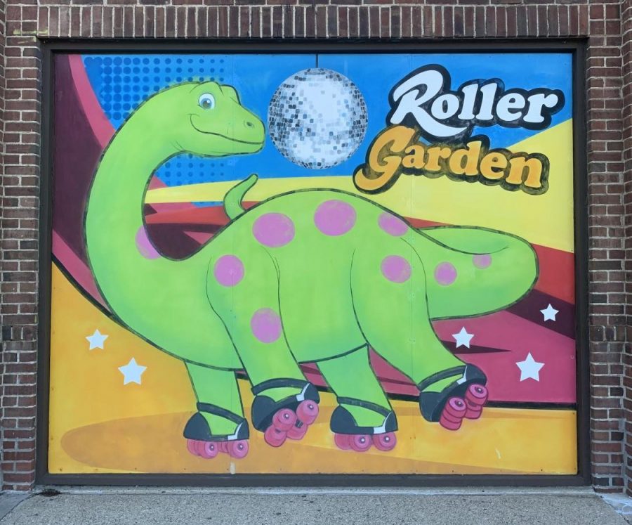 The Roller Gardens signature green dinosaur smiles at skaters before the rink closes this weekend.