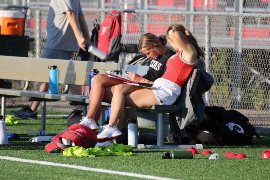 Bailey Skahan and Cassi Gonyea work hard on the bench during the girls soccer game.