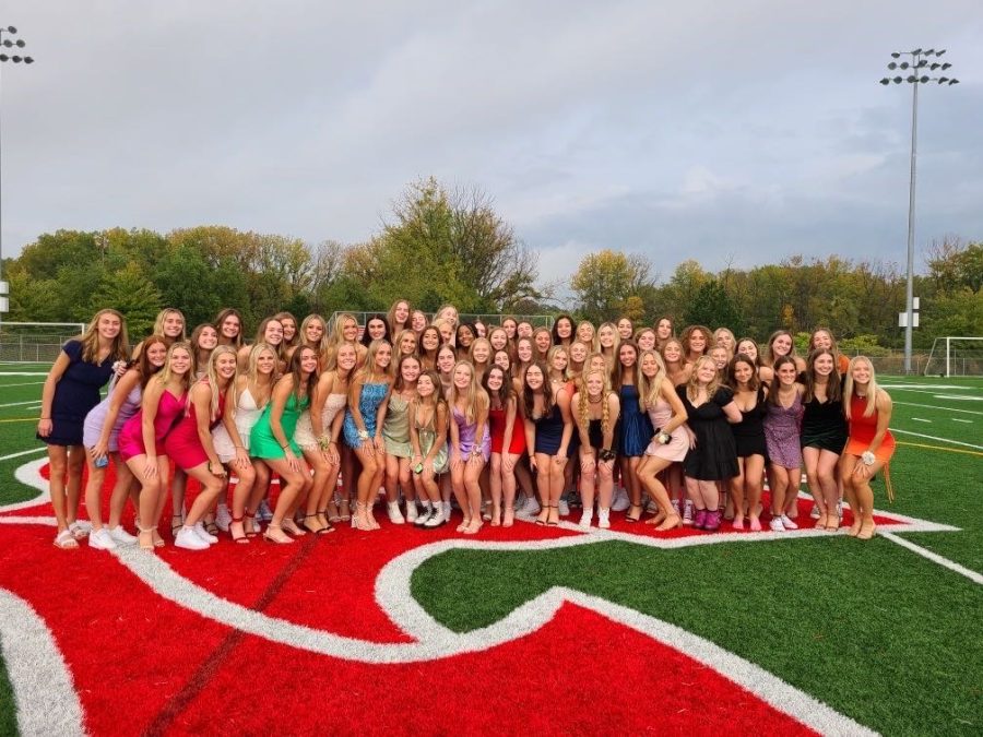 Senior+girls+pose+on+the+turf+before+the+2021+homecoming+dance.