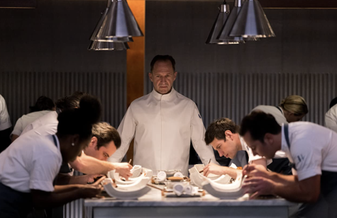 Chef Julian (Ralph Finneas) stands over his devoted sous chefs in the Hawthorne restaurant of The Menu.