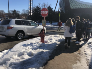 Students wait after school to cross the street to the synagogue lot.