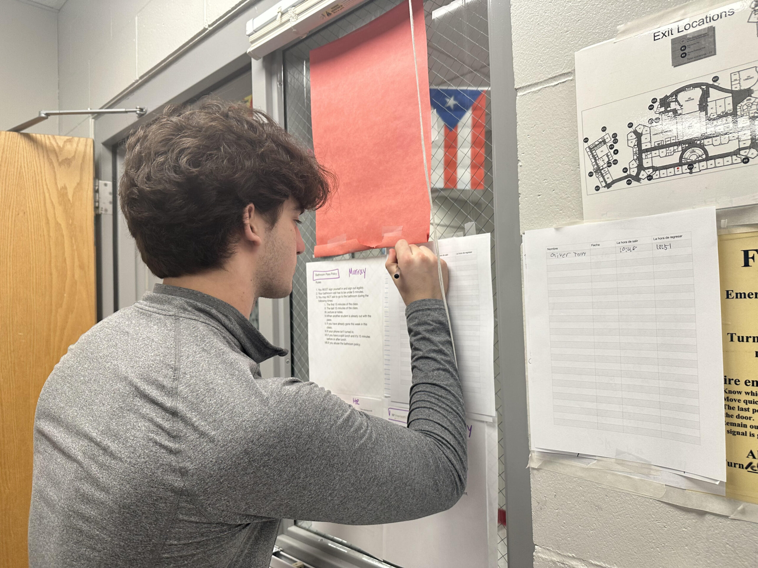 Student in Spanish class using the sign out sheet in order to leave for the bathroom.