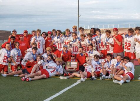 The boys lacrosse team poses for a picture after winning the state championship game for the second year in a row.
