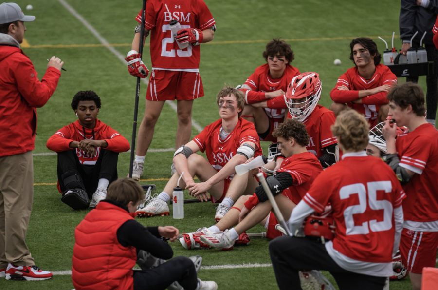 The BSM Boys Varsity Lacrosse Team sits during halftime at one of their games