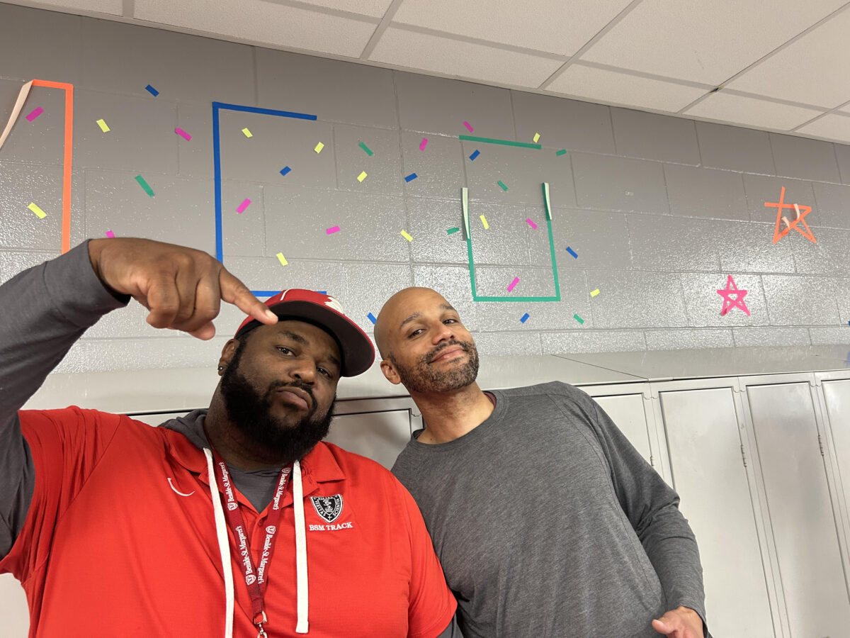 Coach Creer and substitute teacher Mr. Grace pose in front of decorations.