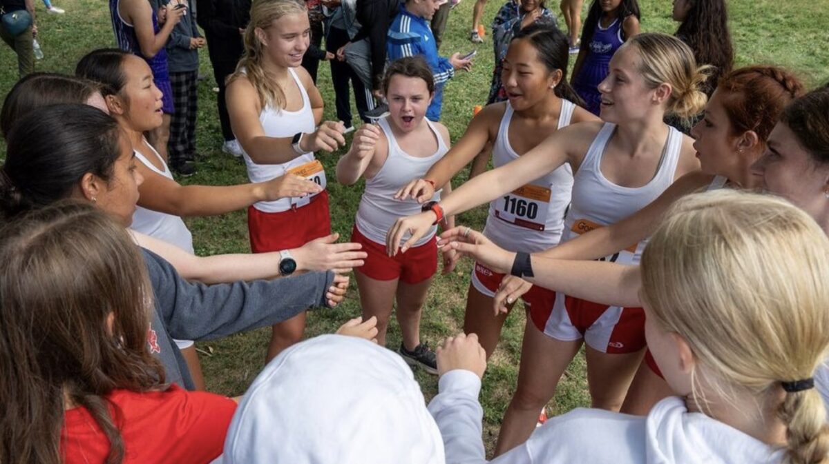 The girls XC team rallies before their first race of the 2023 season.