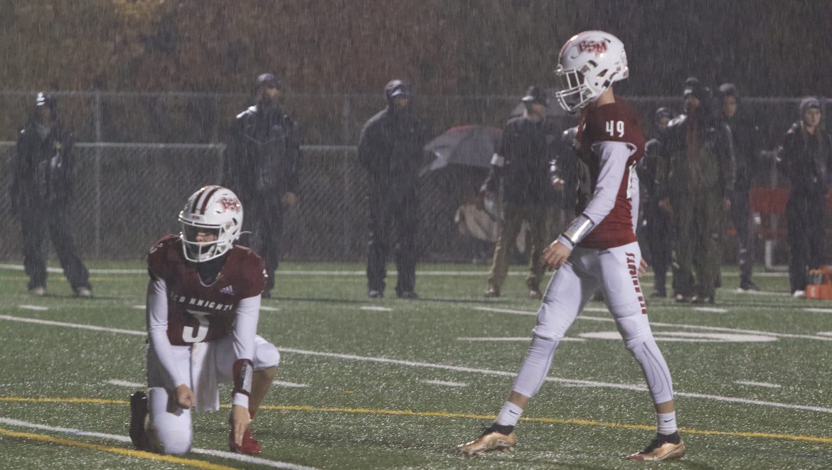 Junior+kicker%2C+Will+Gadtke%2C+lines+up+a+PAT+%28point+after+try%29+in+the+pouring+rain+during+the+game+vs.+Delano.