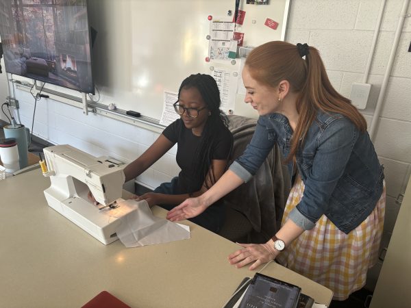 Ms. Bevington teaches Sophomore Tiffany Morara how to use a sewing machine while rocking a homemade dress.