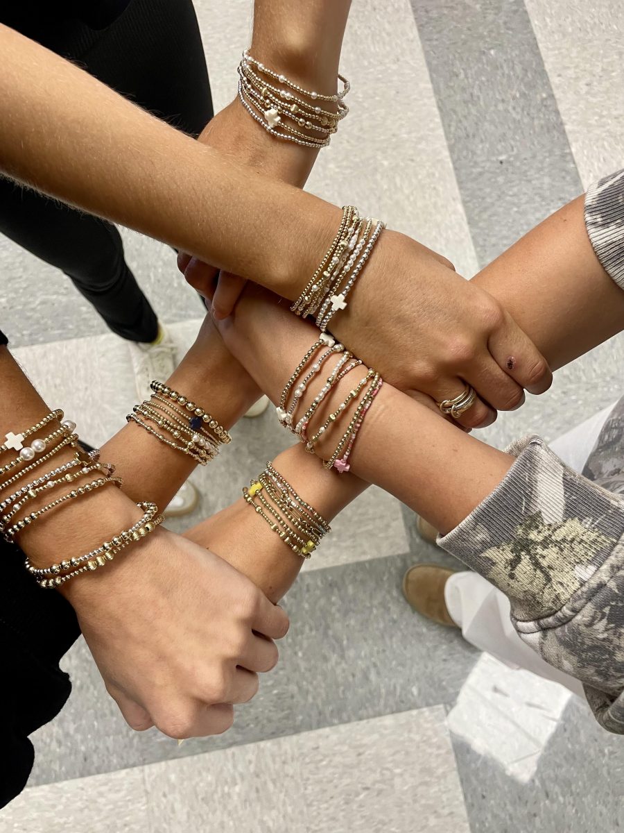 Taylor Winegarner, Rylee Vieau, and Ana Zitzer showing off their E Newton bracelets.