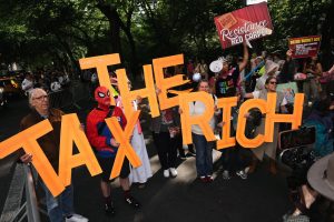 People gather feet away from the Met Gala protesting the event