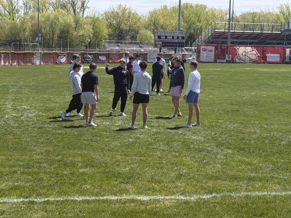 Students get outside in the warm weather to play hacky sack during lunch.